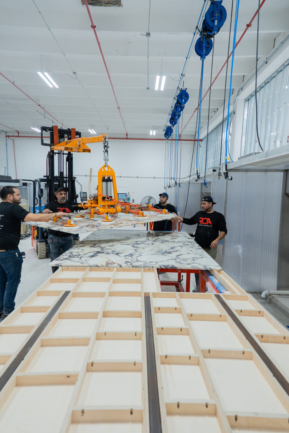 ROA team hoisting a marble slab in the workshop